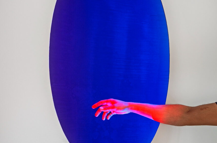 Image from Henry Jackson Spieker's "Void." A hand in front of a blue circle.