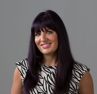 Writer Nicole Rollender headshot with dark hair, smiling