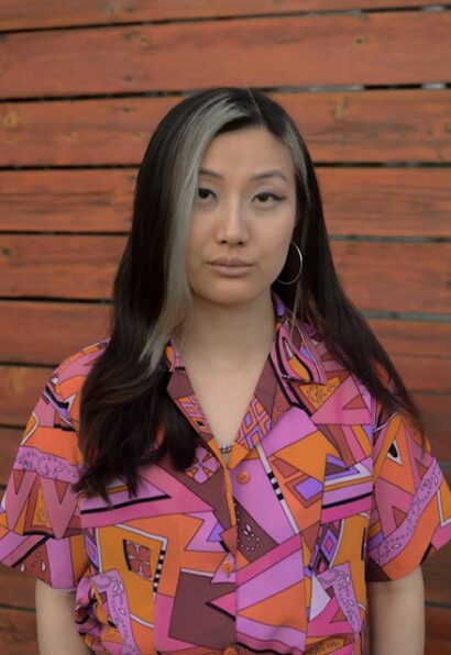 Poet Emdash in a shirt with a pink pattern