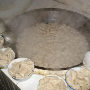 Diana Xin's family dumplings. Plump dumplings on plates surround a steaming wok.
