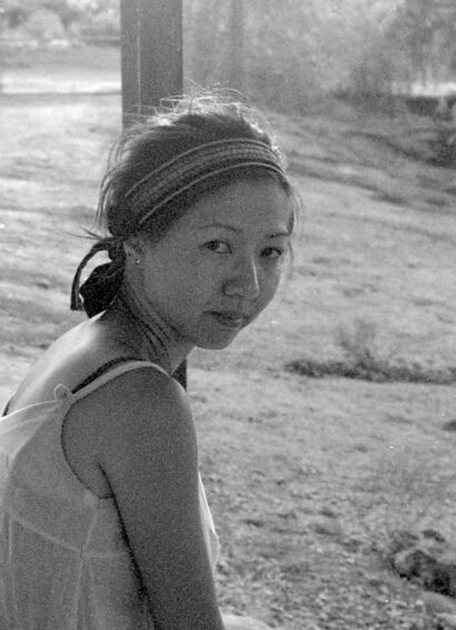 Jennifer S Cheng in a black and white photo, wearing a tank top and headband