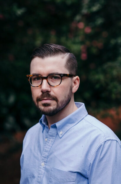 Poet William Fargason in a blue button down shirt and eyeglasses.