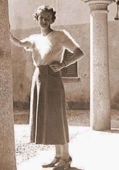 Poet Antonia Pozzi standing in a dress in a courtyard