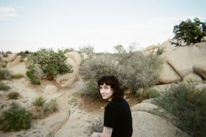 Miriam in a black shirt with dark hair in front of a desert landscape