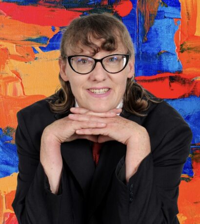 Crédito de foto, Fotografía Avila. Allison with glasses and medium length brown hair in a black shirt, in front of an orange, blue. and red painting