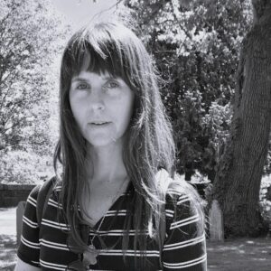 Managing Editor Kelsey Tribble in a striped shirt with bangs and long hair.