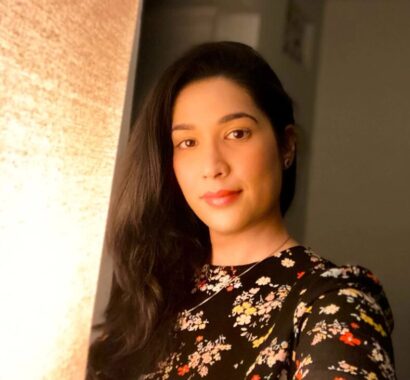 Areej poses next to a window wearing a floral pattern.