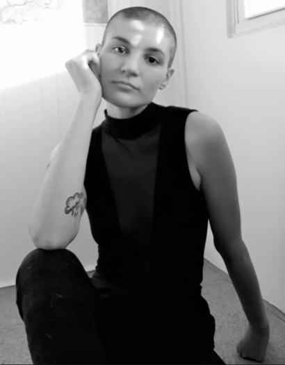 Black and photo of Jax sitting in floor in a black tank top.