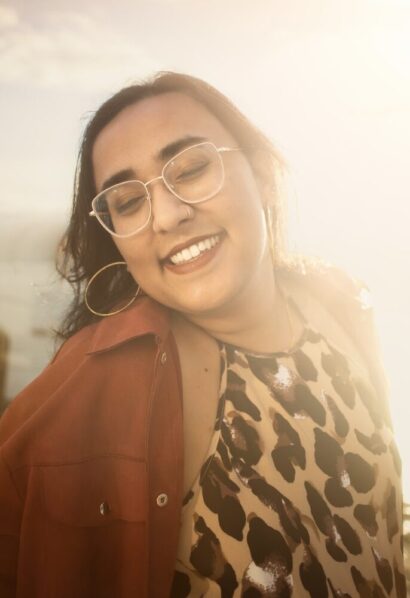 Yaminee smiling in a brown shirt in the sun