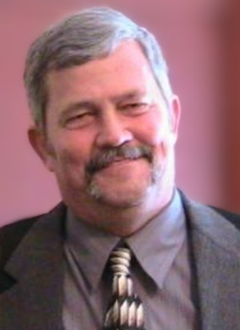 Headshot of Randy Hudson looking directly at the camera wearing a suit and tie against a mauve backdrop.