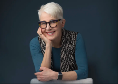 Linda Button's Headshot, Smiling in a Studio