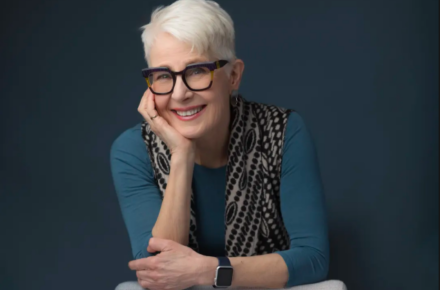 Linda Button's Headshot, Smiling in a Studio
