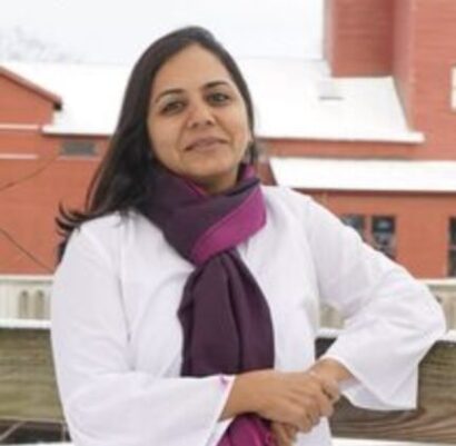 Author Manisha Sharma looks into the camera smiling slightly