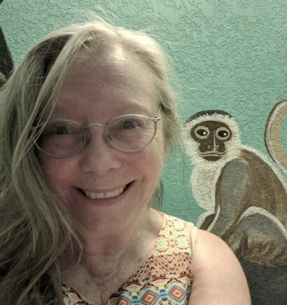 Photo of Holly with a background image of a monkey on the wall